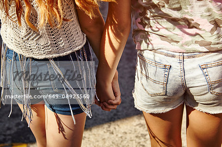 Teenage girls in street, rear view of shorts and hands