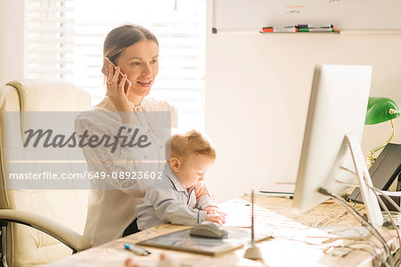 Mother working and caring for baby at home
