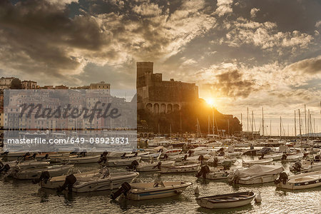 View of harbour yachts and castle at sunset, Lerici, Liguria, Italy