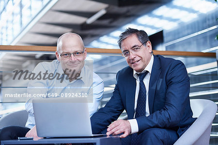 Portrait of two mature businessmen meeting on office balcony