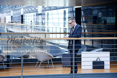 Businessman looking at smartphone on office balcony