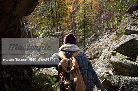 Young woman hiking, leaning on rock, rear view, Sverdlovsk Oblast, Russia