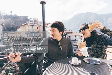 Couple taking smartphone selfie at restaurant, Monte San Primo, Italy