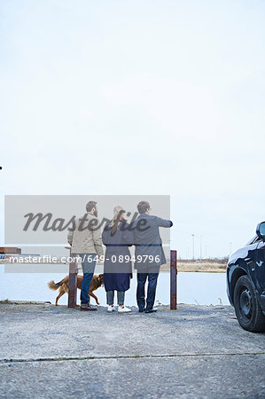 Rear view of design team pointing over waterfront outside design studio