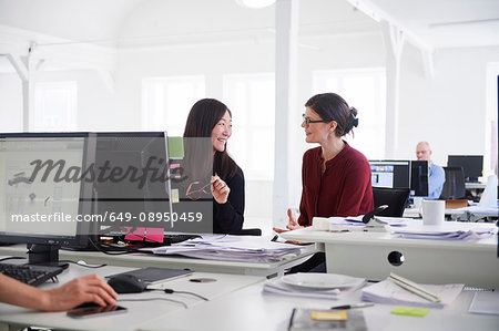 Colleagues working in office, using computer