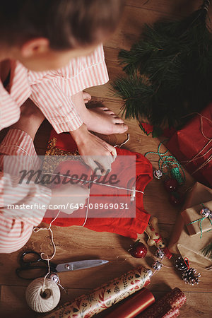 Woman wrapping christmas gift with twine