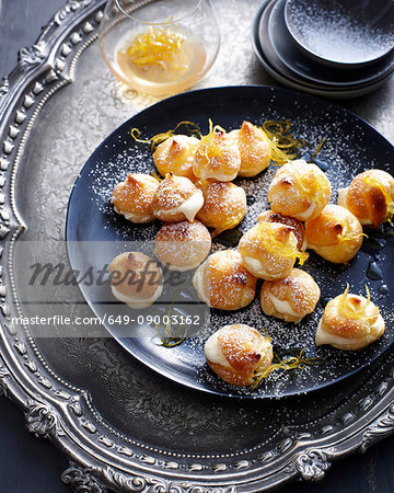 Plate of cream puffs with orange peel