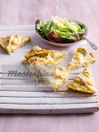 Tray of sliced quiche with salad