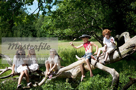 Children in costumes playing on tree