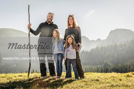 Portrait of mature couple and two daughters in sunlit mountain landscape, Bavaria, Germany