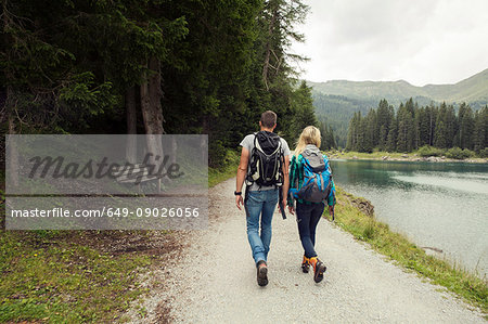 Rear view of couple hiking by lake, Tirol, Steiermark, Austria, Europe