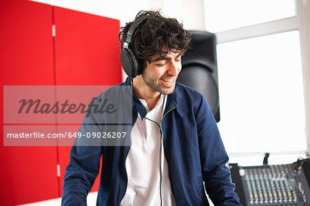 Young male college DJ student listening to music on headphones Young male college DJ student listening to music on headphones
