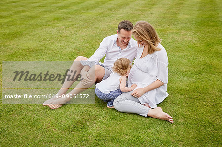 Couple with daughter on green lawn