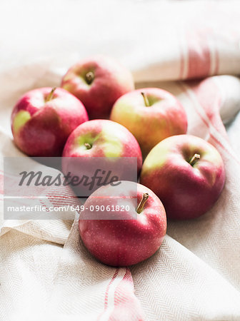 Six red apples on linen kitchen cloth, close-up