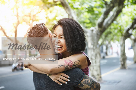 Multi ethnic hipster couple hugging on street, Shanghai French Concession, Shanghai, China