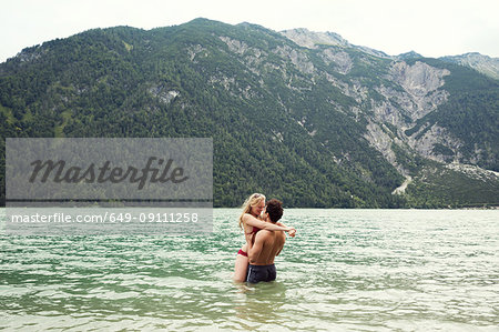 Couple waist deep in water kissing, Achensee, Innsbruck, Tirol, Austria, Europe