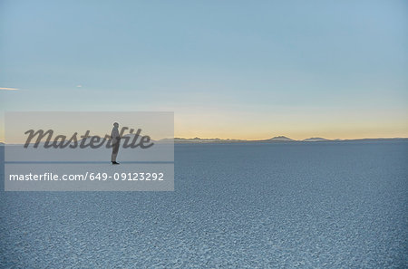 Woman standing on salt flats, looking at view, Salar de Uyuni, Uyuni, Oruro, Bolivia, South America