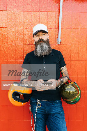 Portrait of mature male hipster in front of red wall