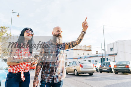 Mature hipster couple hailing a cab, Valencia, Spain