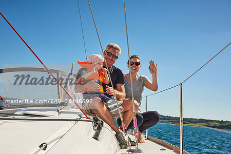 Senior man with daughter and granddaughter on yacht, portrait, Devon, UK