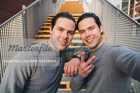 Young adult male twins training together, stairway self  portrait