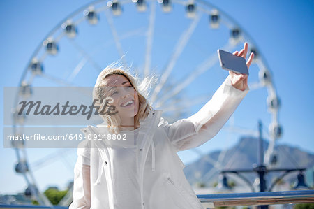 Woman taking selfie in front of Cape Wheel, Victoria and Alfred Waterfront, Cape Town, South Africa