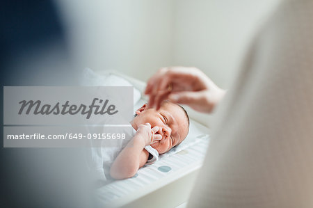 Mother and father looking at newborn baby, focus on baby