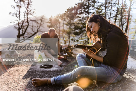 Man and woman relaxing, cooking food and playing guitar on The Malamute, Squamish, Canada
