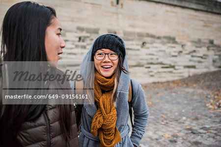Two young female tourists talking on riverbank, Paris, France