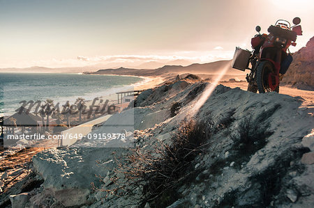 Motorcycle on cliff by coastline, Cabo San Lucas, Baja California Sur, Mexico