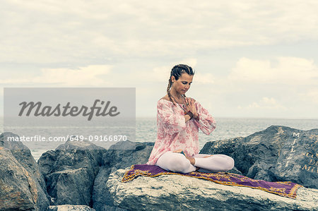 Woman meditating by sea