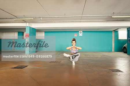 Woman practising yoga in parking lot