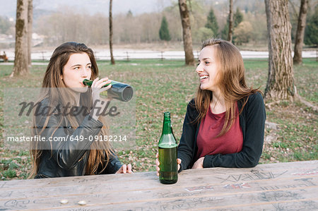 Girlfriends drinking beer in park