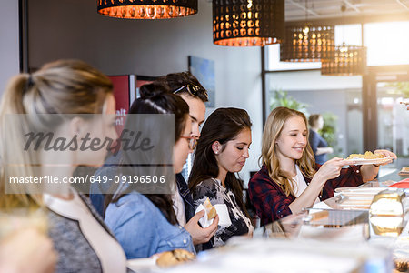 Young male student and female friends at cafe counter
