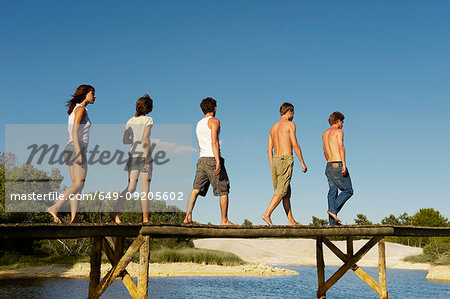 Group of young people walking on jetty