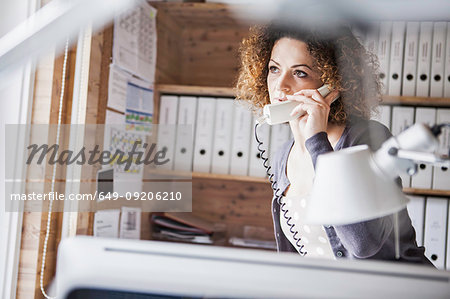 Businesswoman talking on phone in office