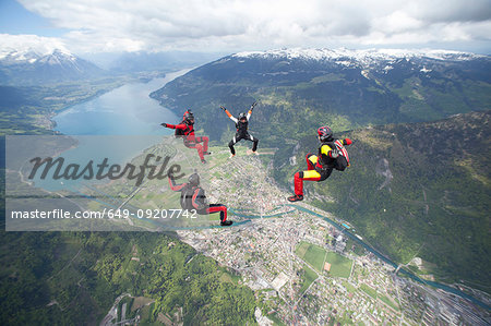 Team of four skydivers in formation over Interlaken, Berne, Switzerland Team of four skydivers in formation over Interlaken, Berne, Switzerland
