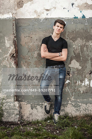 Teenage boy leaning against wall