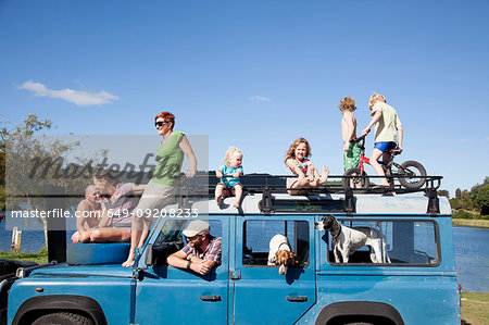 Family friends on top of off road vehicle, Lake Okareka, New Zealand