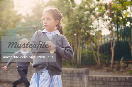Elementary schoolgirl eating cracker in playground