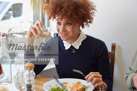 Young woman having lunch with friends in cafe