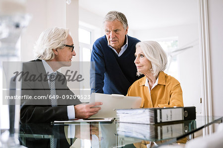 Senior adults in business meeting discussing paperwork