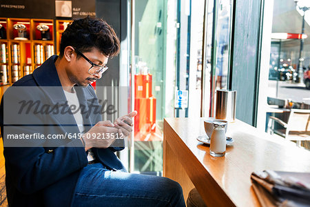 Businessman using smartphone in cafe