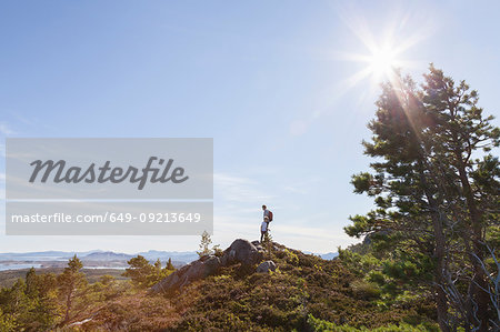 Boy and father looking out from woodland hill over landscape, Aure, More og Romsdal, Norway