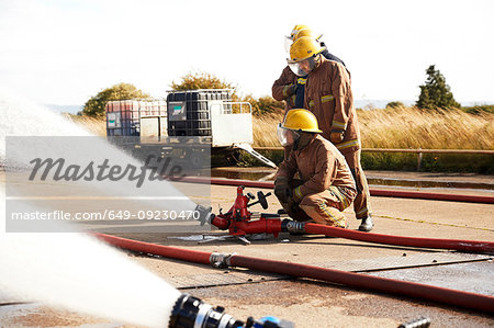 Firemen training to use fire hose, Darlington, UK