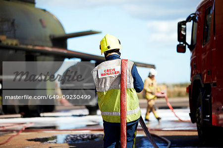 Fireman carrying fire hose over shoulder, Darlington, UK