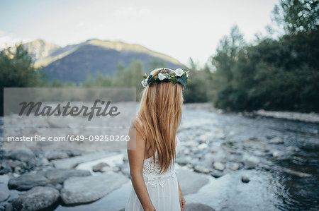 Woman in white dress looking back at river, Orta, Piemonte, Italy