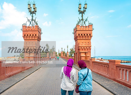 Two female tourists taking photograph on Montaza palace bridge, Alexandria, Egypt