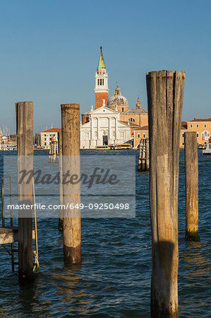 Wooden mooring posts, canal lane markers, Benedictine Church, Campanile bell tower, San Giorgio Maggiore Island, San Marco district, Venice, Veneto, Italy
