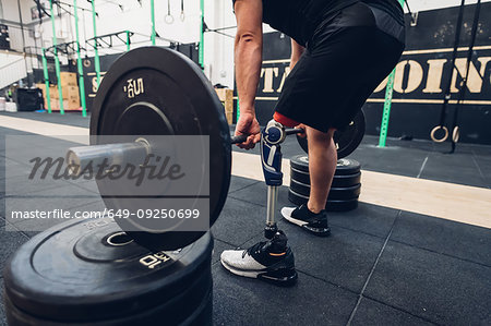 Man with prosthetic leg weight training in gym